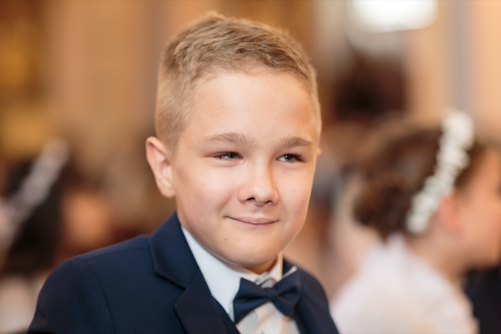 Uśmiechnięty Sebastian w eleganckim stroju podczas Pierwszej Komunii